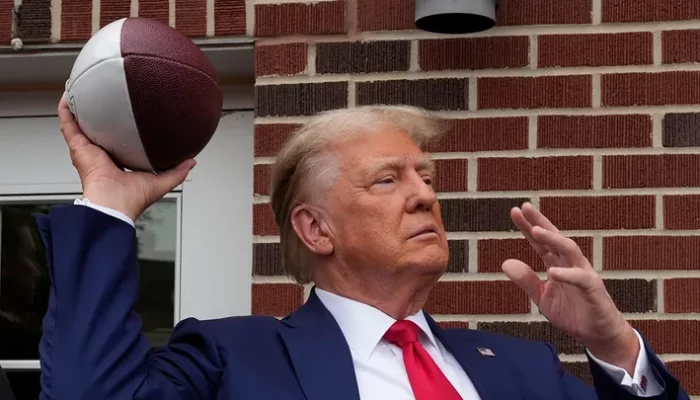 Donald Trump tailgates before the Iowa-Iowa State game, and the crowd erupts as he steps into the stadium.