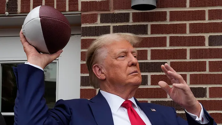 Donald Trump tailgates before the Iowa-Iowa State game, and the crowd erupts as he steps into the stadium.